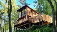 Une cabane moderne dans les arbres vue du sol de Victor et Anne-Émilie De Sousa